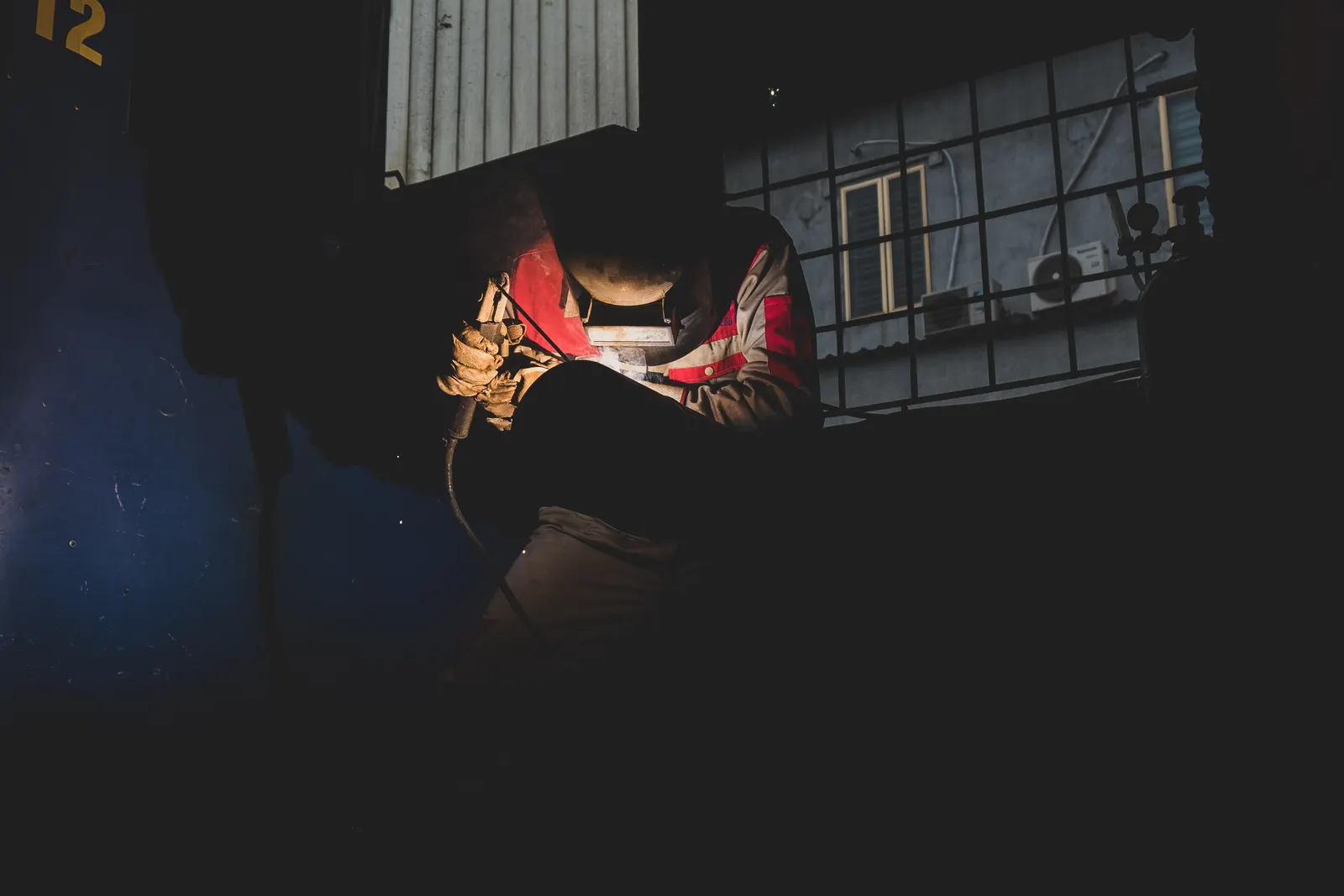 Welder working in a controlled industrial setting